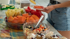 Una mesa de buffet con diversas frutas y aperitivos.