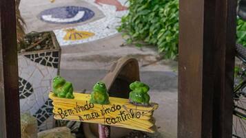 A courtyard with a mosaic floor, hanging light fixtures, and a wooden sign with frogs.