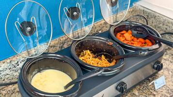 A buffet with three covered dishes: a creamy soup, a dish with shredded vegetables, and a dish with carrots.