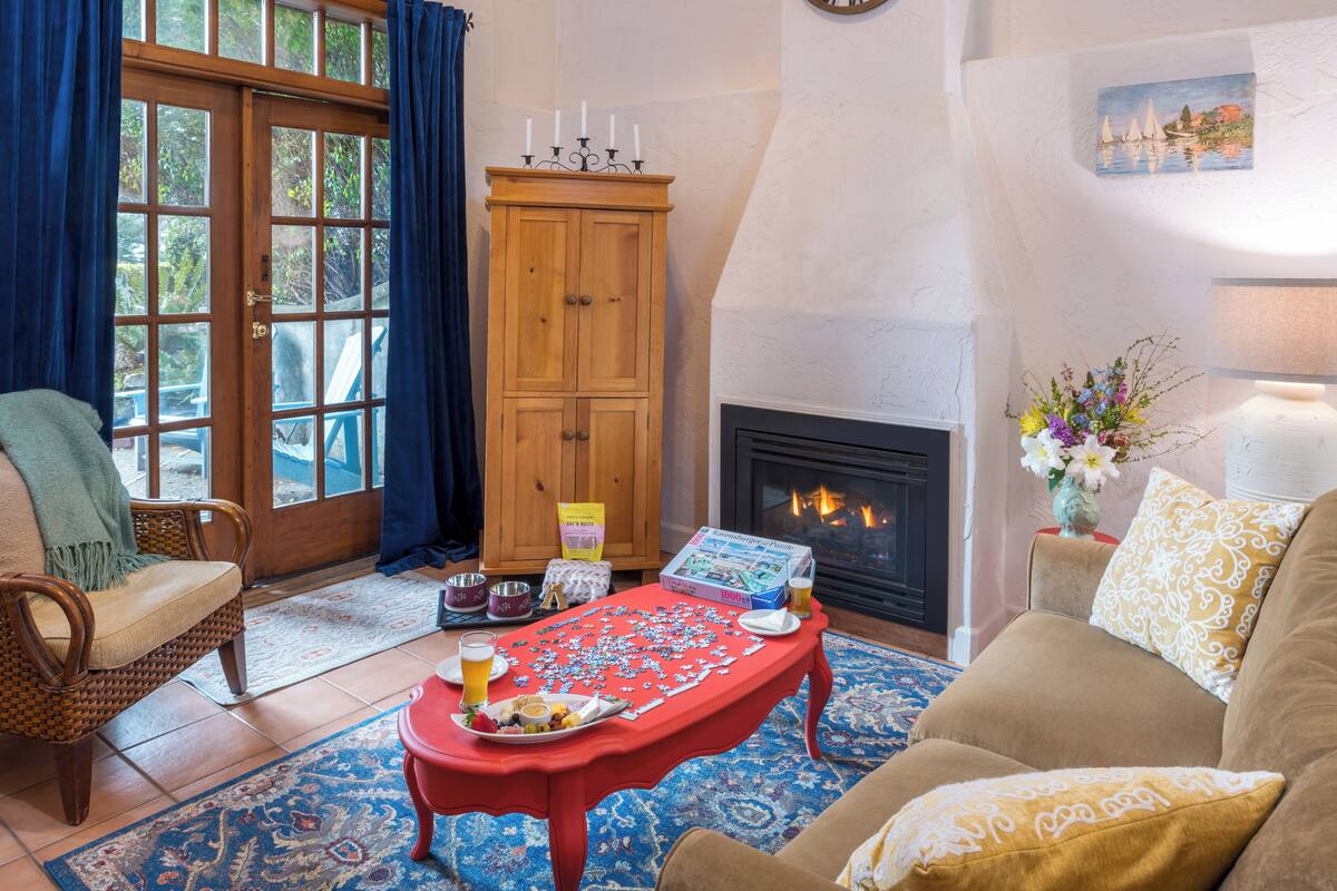 A cozy living room with a fireplace, a jigsaw puzzle on a table, and a comfortable seating area.