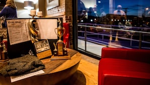 A wooden reception desk with trophies, a framed photo, and a menu. - Jackson Park Inn, an Ascend Collection Hotel (Pulaski)