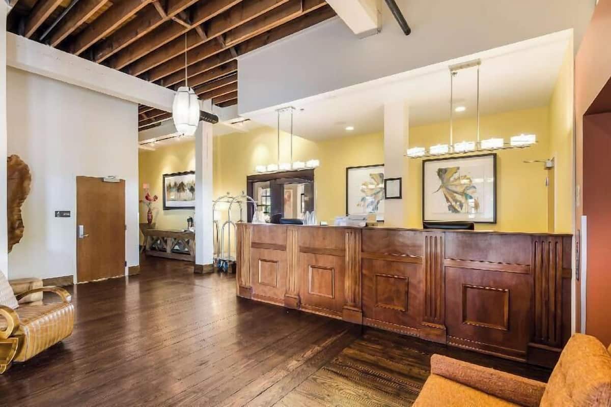 A reception area with a wooden reception desk, a hanging light fixture, and framed artwork on the walls.