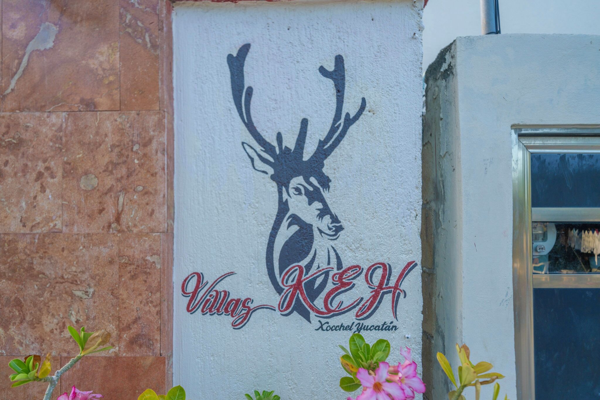 A wall with a deer head logo and the text "Villas KEH Xocchel Yucatan".