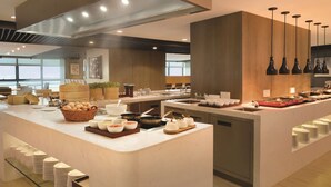 Una cocina moderna con una isla central, electrodomésticos de acero inoxidable y una variedad de alimentos y utensilios.