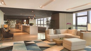 A modern hotel lobby with a sectional sofa, a coffee table, and a patterned rug. - Hyatt House Shenzhen Airport (Shenzhen)