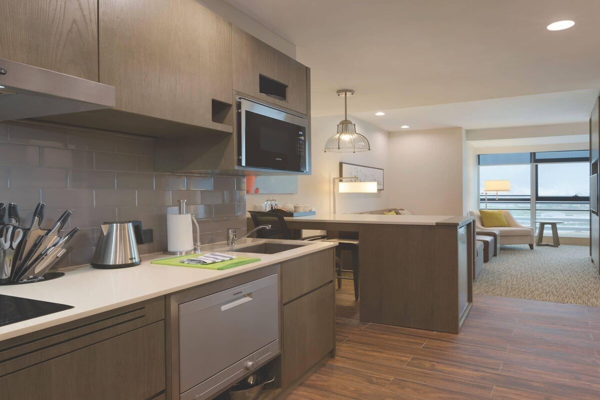 Una cocina moderna con armarios de madera, electrodomésticos de acero inoxidable y una isla grande.