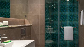 A modern bathroom with a large sink, toilet, and shower area.