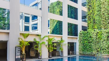 Una piscina al aire libre, sillones reclinables de piscina
