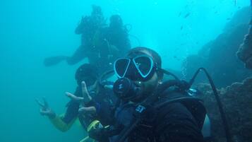A diver making a peace sign underwater.