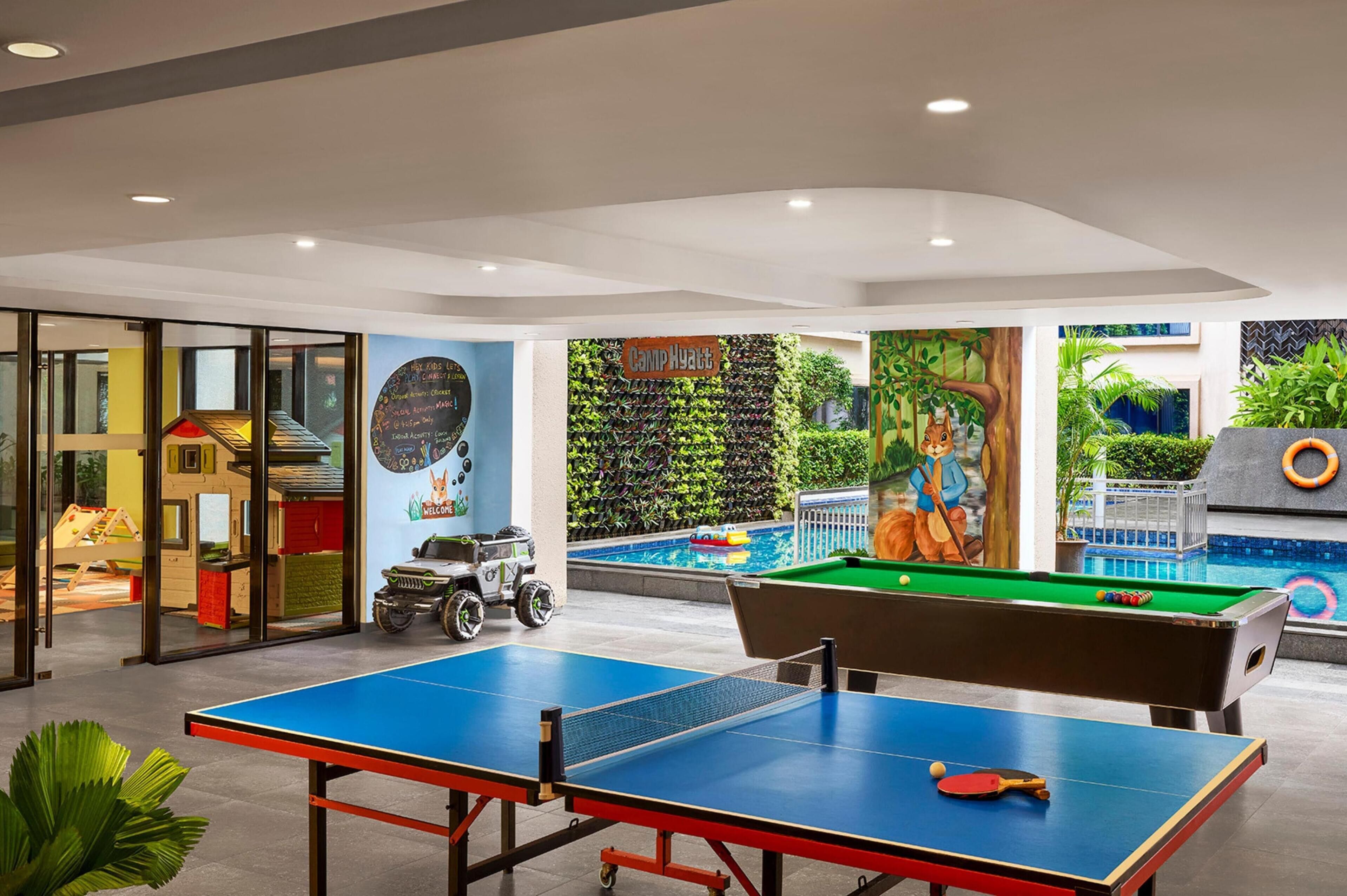 A pool table, ping pong table, and a pool with a mural.