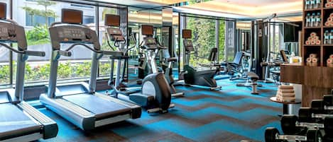 A gym with treadmills, elliptical machines, and weight benches.