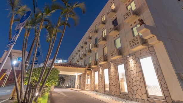 Un hotel con fachada moderna, balcones y una entrada bien iluminada.