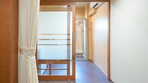 Un pasillo con una puerta corrediza de vidrio que da a una habitación.