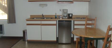 A compact kitchen with a microwave, coffee maker, and dishwasher.