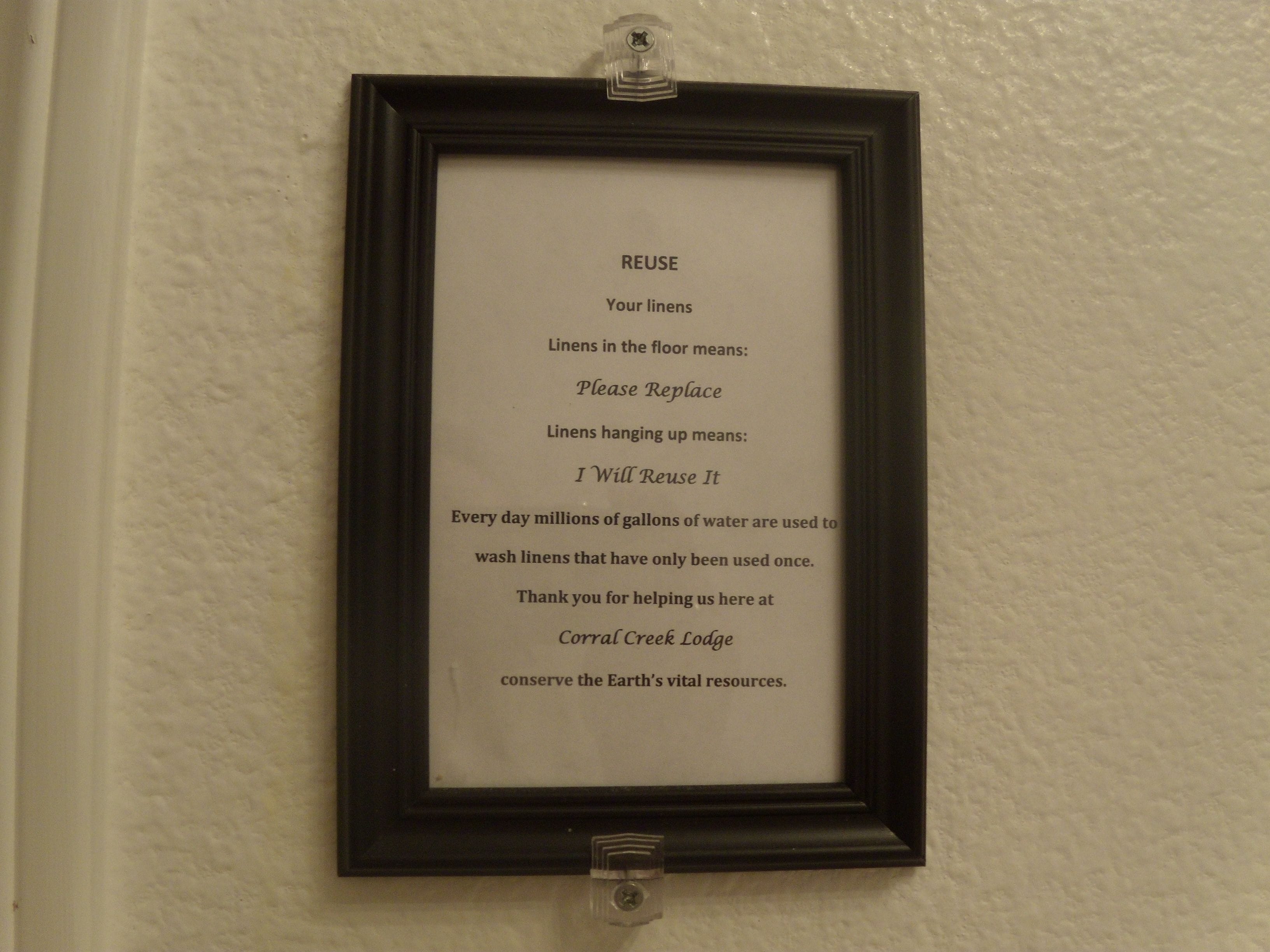 A framed notice on a wall about linen reuse.