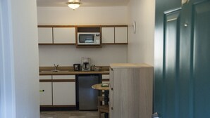 Cocina compacta equipada con microondas, cafetera y lavavajillas.