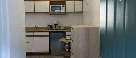 A compact kitchen with a microwave, coffee maker, and dishwasher.