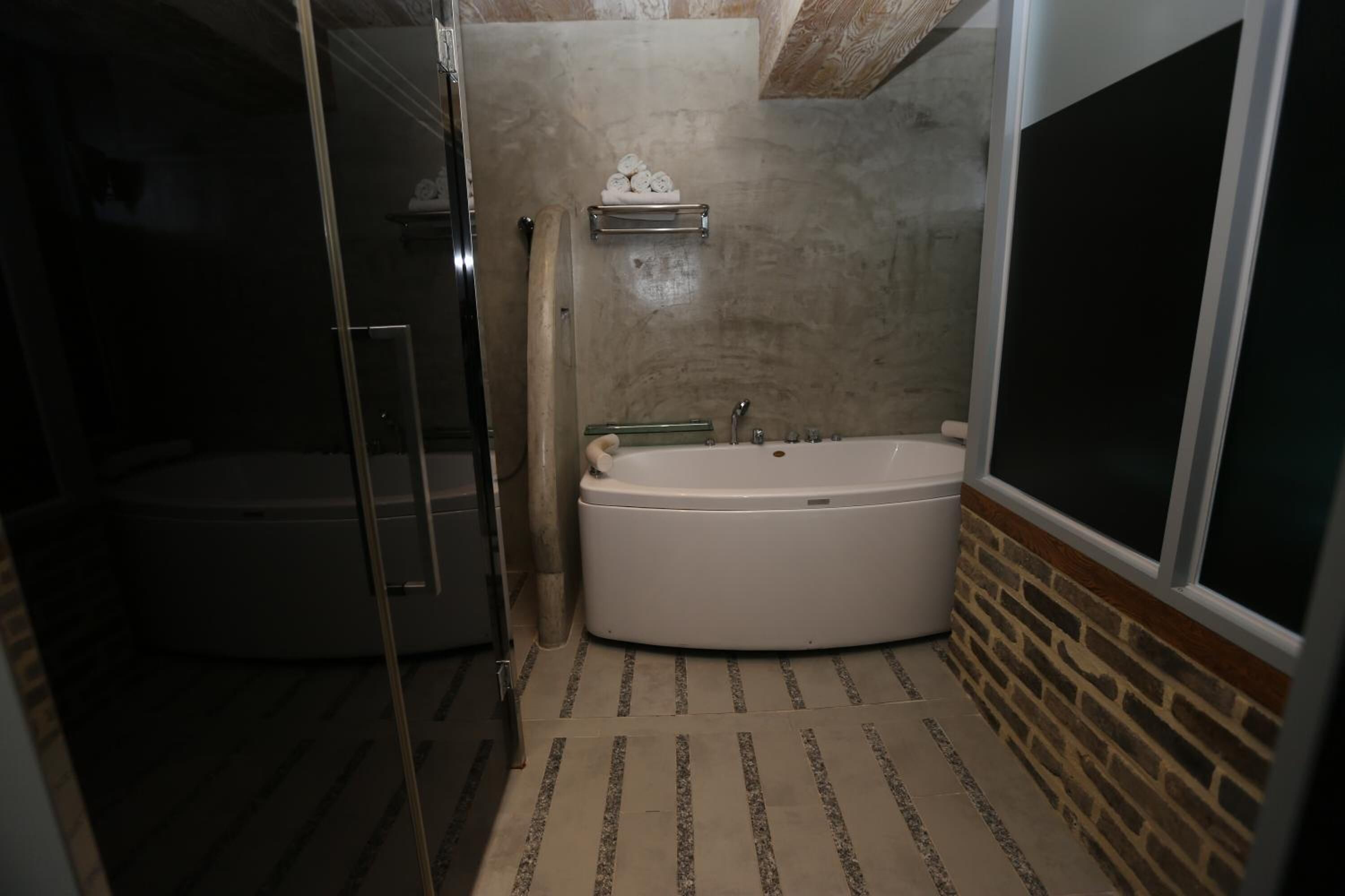 Ein Badezimmer mit einer begehbaren Dusche, einer Badewanne und einem Handtuchhalter.