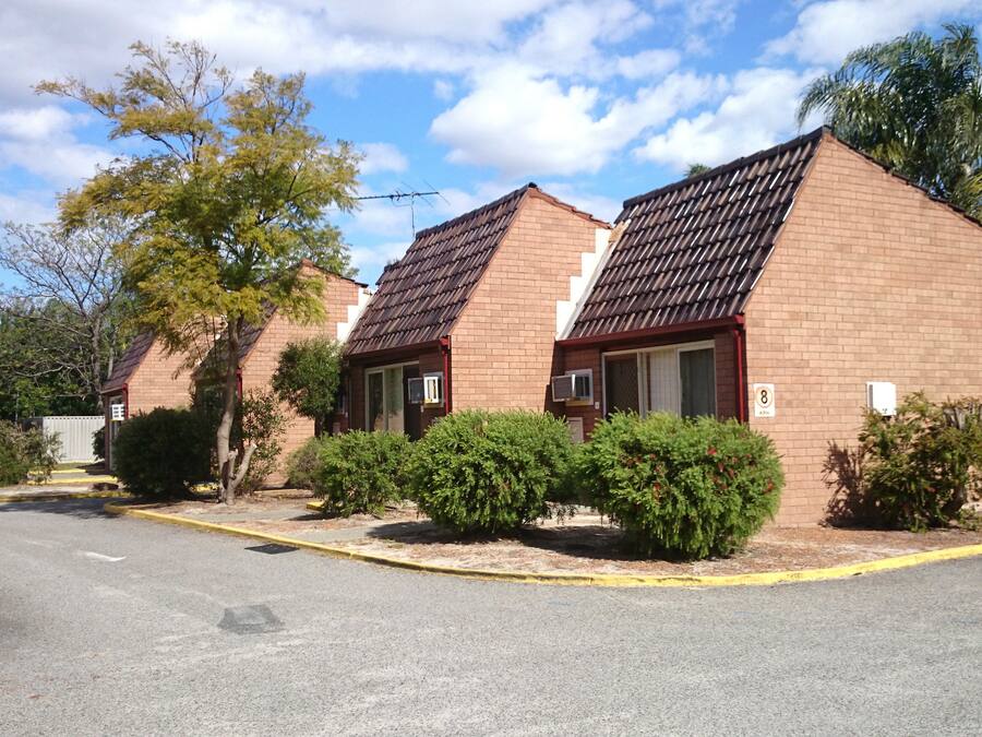 A row of brick buildings with pitched roofs, likely a residential or hotel complex.