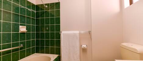 A bathroom with a bathtub, toilet, and shower.