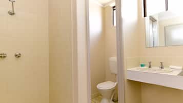 Un baño con inodoro, lavabo y ducha.
