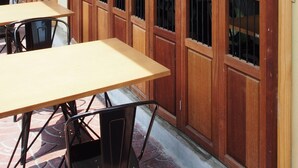 A restaurant with wooden sliding doors, tables, and chairs. - Bangkok Story - Hostel (Bangkok)