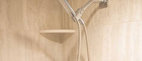 A shower with a handheld showerhead and a handheld hose.