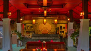 A restaurant with a wooden table, chairs, and a red ceiling. - E-outfitting Pai Resort (Pai)