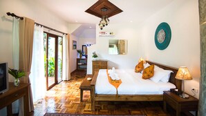 A bedroom with a wooden bed, a TV on a stand, a wooden nightstand, and a view of the outdoors. - E-outfitting Pai Resort (Pai)