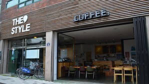 A coffee shop with a modern design, featuring a wooden facade and a glass entrance. - The Style Capsule Guesthouse - Hostel (Daegu)