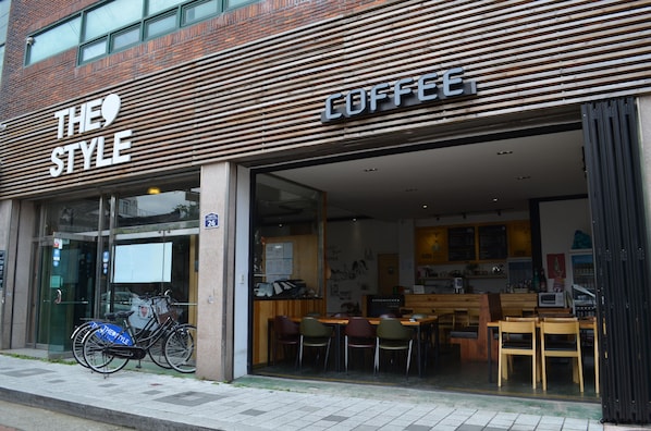 A coffee shop with a modern design, featuring a wooden facade and a glass entrance. - The Style Capsule Guesthouse - Hostel (Daegu)