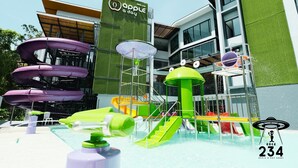 A water park with slides and a building with a sign that reads "Apple Day".