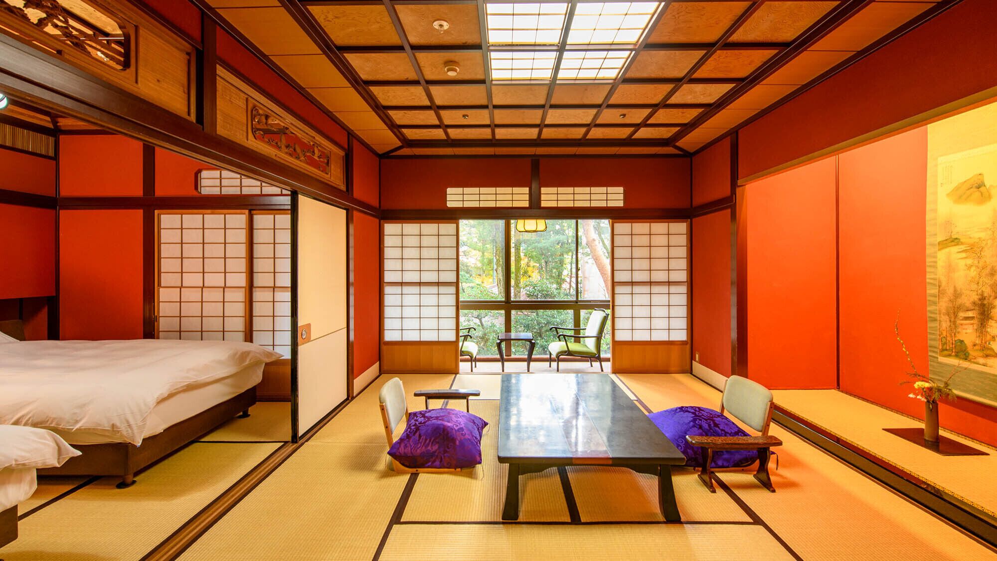 A traditional Japanese room with tatami flooring, a low table, chairs, and a bed.