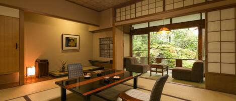 A traditional Japanese room with tatami flooring, a low table, and seating.