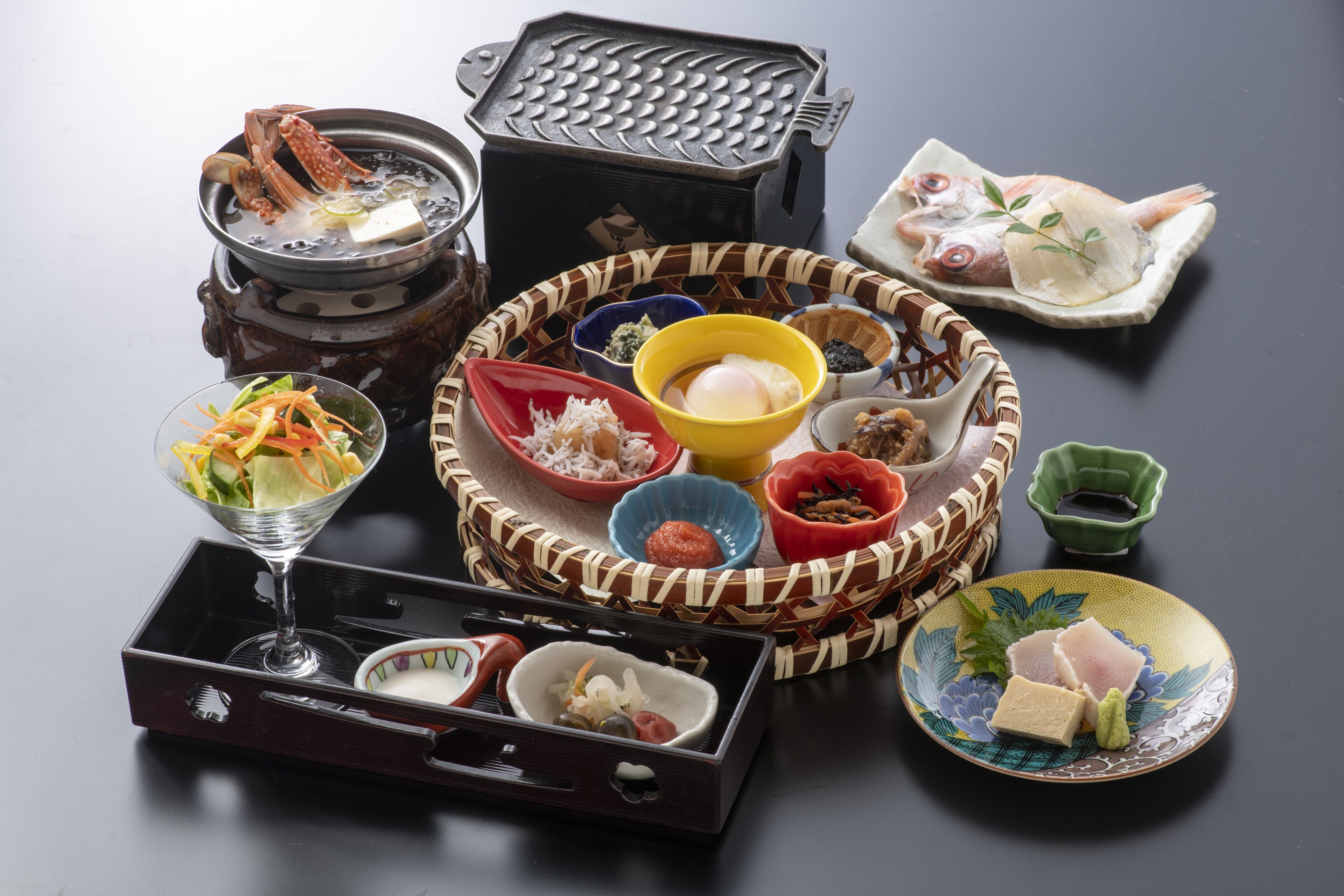 A traditional Japanese hot pot setup with various ingredients and condiments.