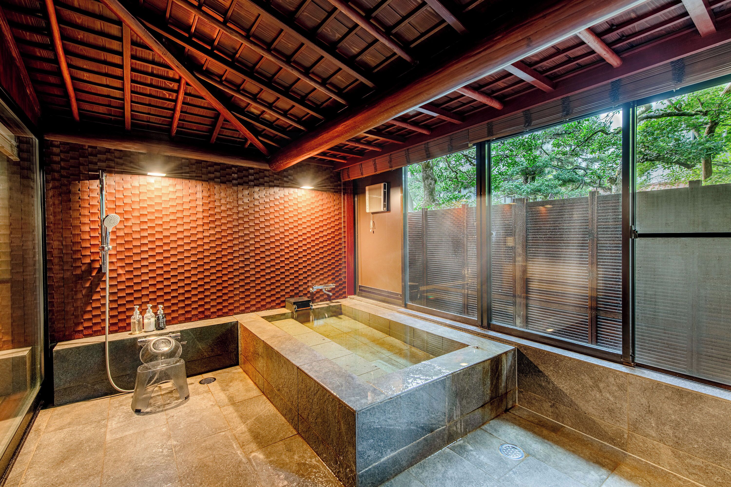 A modern bathroom with a large bathtub, a shower, and a glass enclosure.
