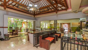 A spacious lobby with a high ceiling, wooden beams, and a central seating area with benches. - The Sesari Jimbaran (Jimbaran)