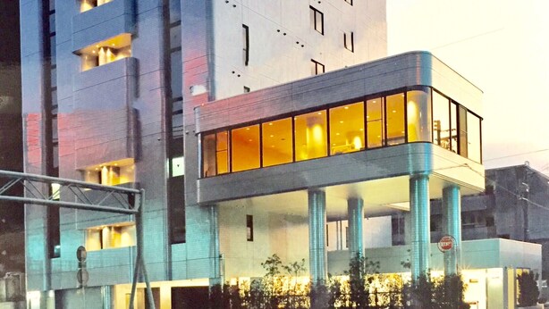 Un bâtiment moderne à la structure à deux étages, doté de grandes fenêtres et d’un toit plat.