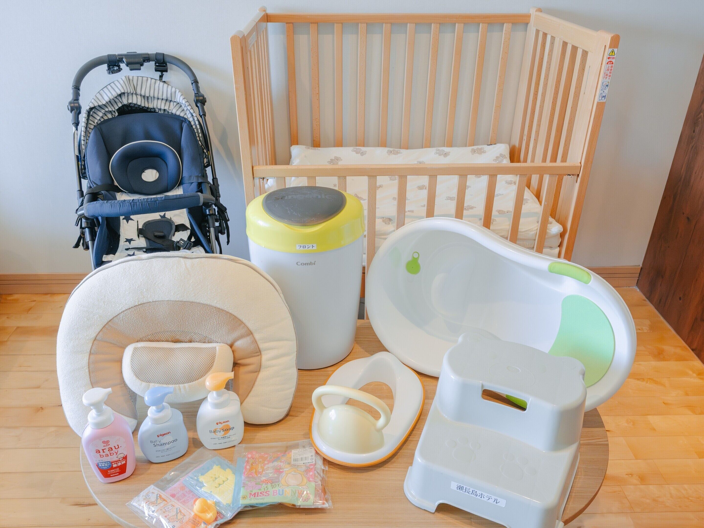 Espaço para troca de fraldas com berço, trocador e produtos para bebê.