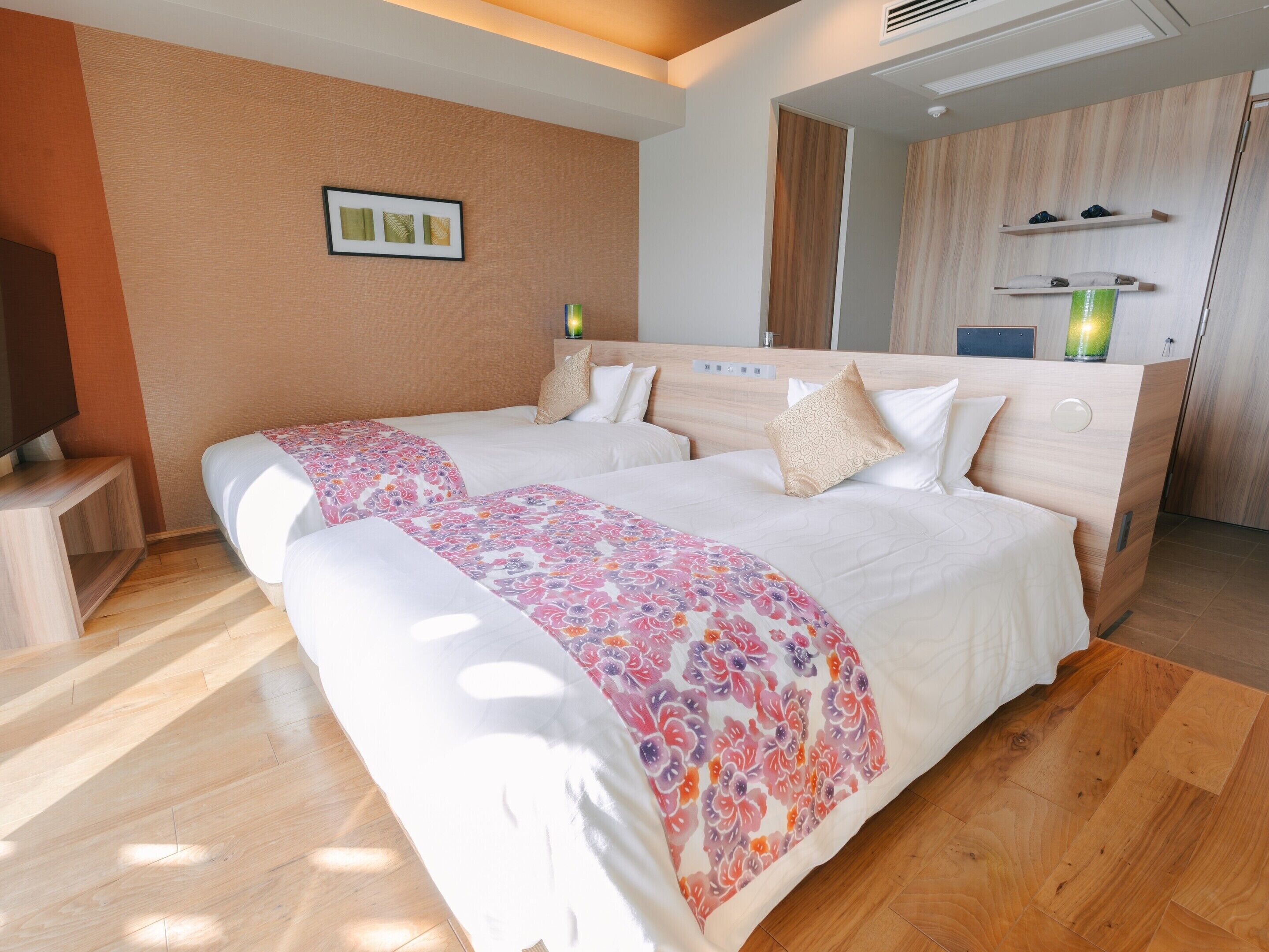 Una habitación de hotel con una cama grande, una mesita de noche, un televisor y un espejo.