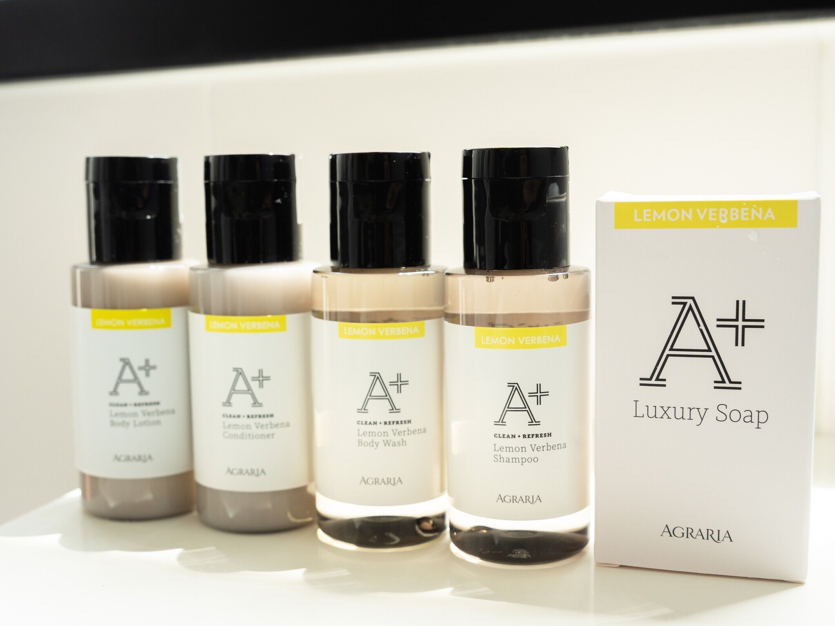 Four bottles of AGRARIA Lemon Verbena body care products and a box of AGRARIA Luxury Soap.