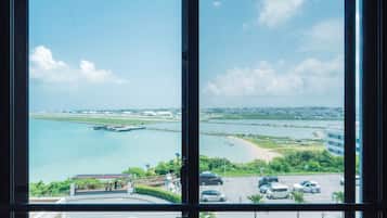 A view through a window of a coastal area with a marina, a bridge, and a parking lot.