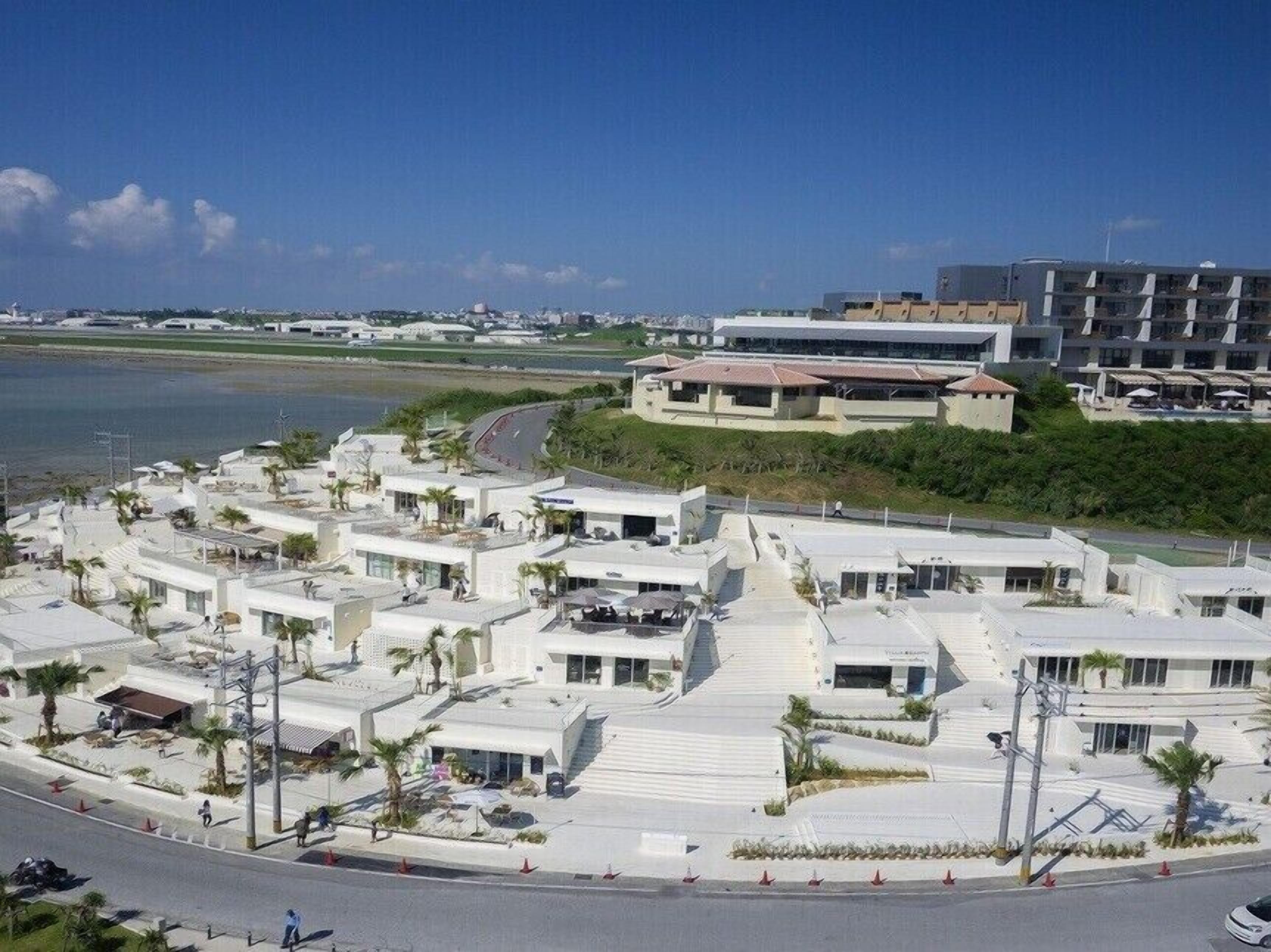 A coastal hotel with multiple buildings, a beach, and a marina.