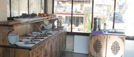 Mesa de buffet con diferentes opciones de comida y vista al exterior.