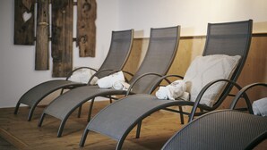 A row of reclining chairs with towels, wooden wall decor, and a wooden floor. - Der Klostertalerhof (Klösterle am Arlberg)