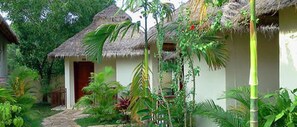 A thatched-roof structure surrounded by lush greenery.