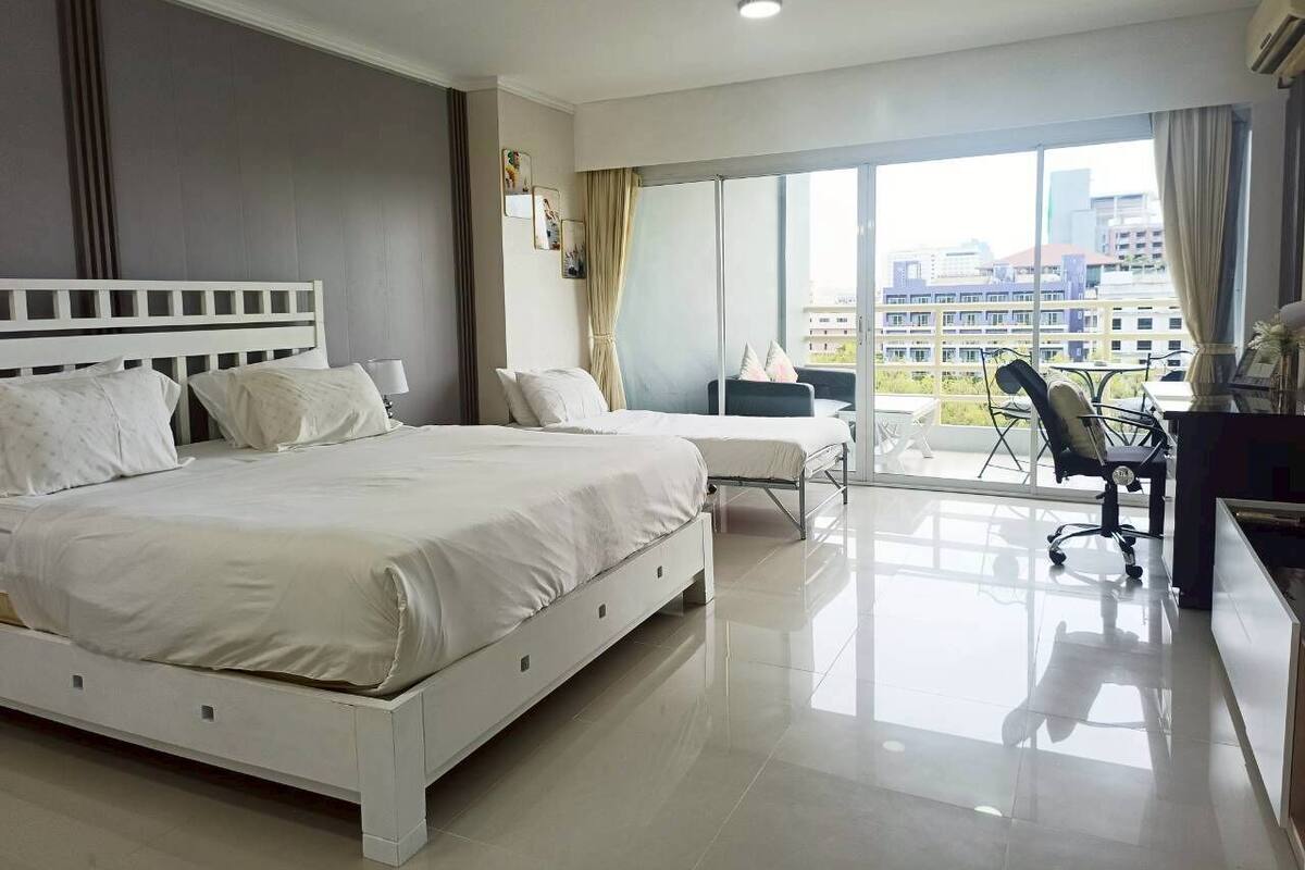 Une chambre d’hôtel moderne, dotée d’un grand lit, d’un bureau et d’une chaise.