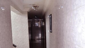 Un pasillo con paredes de mármol y un ventilador de techo.