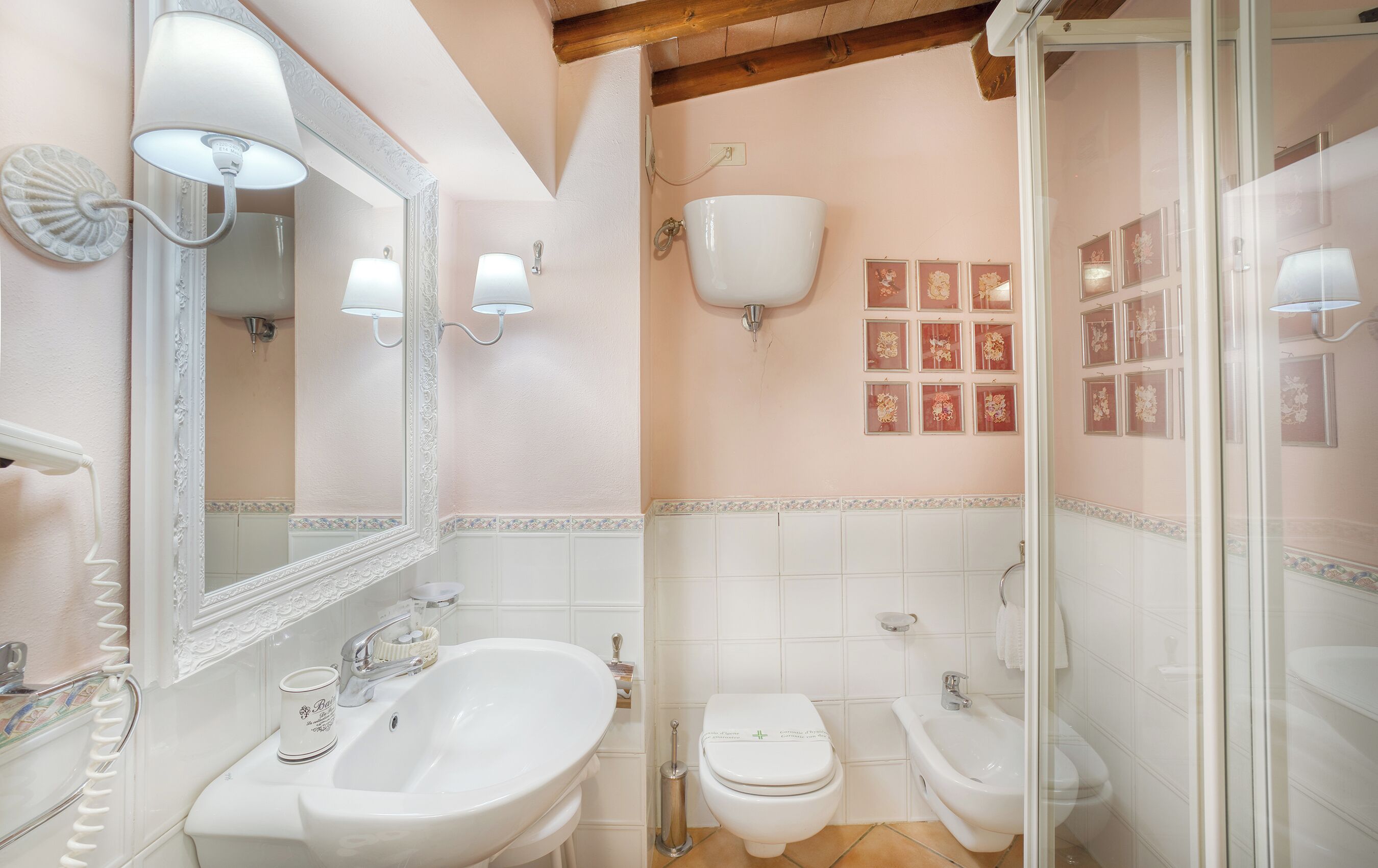 Un bany amb rentatge, mirall, vàter, bidet i plat de dutxa.