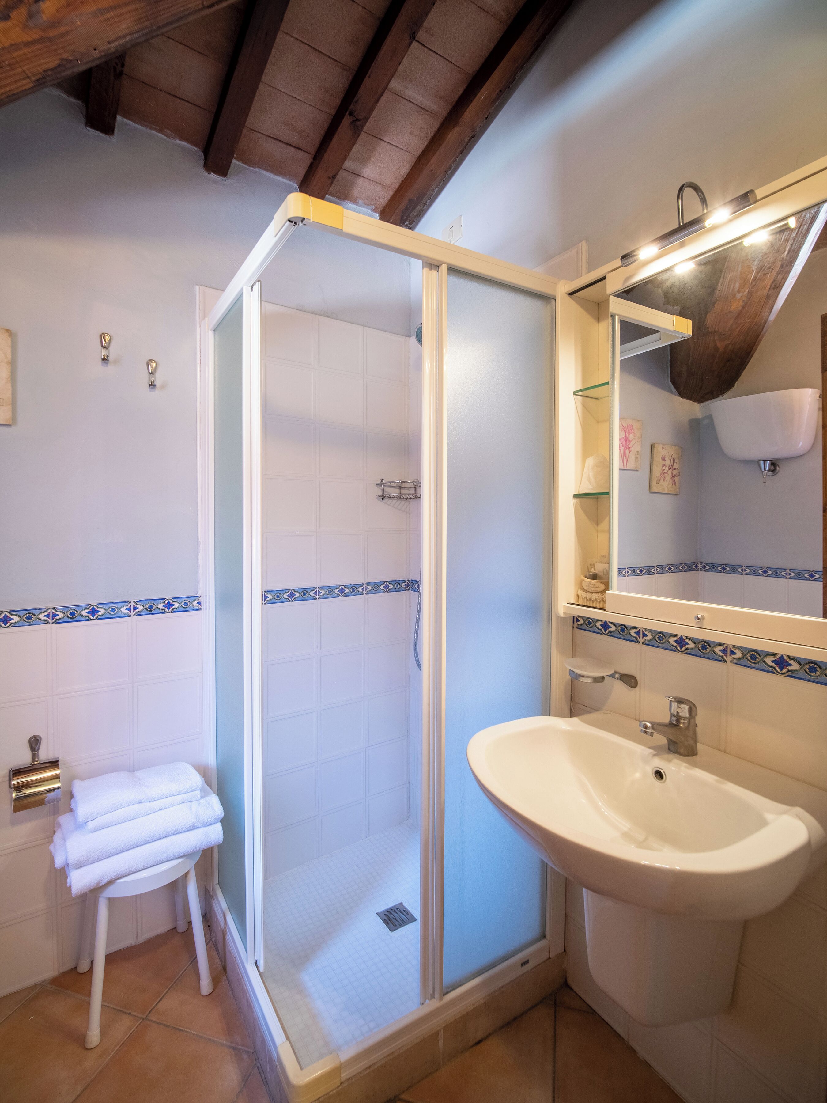 A bathroom with a shower, sink, and mirror.